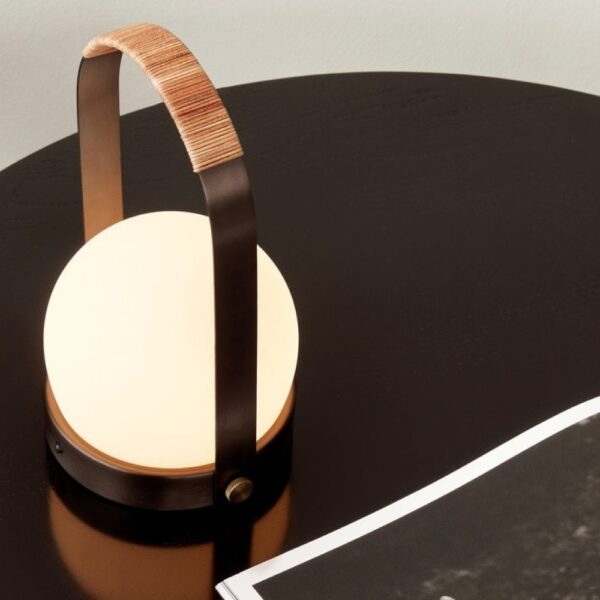 Top view of a portable hand-carry round shaped lamp on a table.
