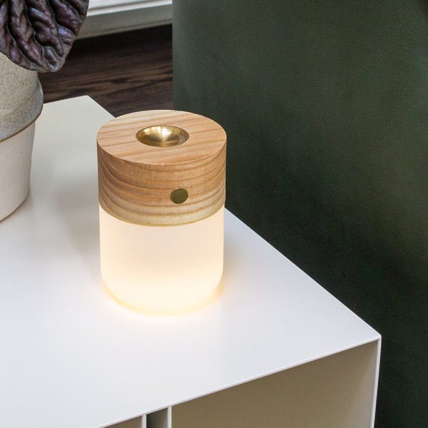 The Gingko Smart Diffuser Lamp in Natural White Ash sits lit up on a Kristina Dam Studio Curve Side Table in the house of Bea Lambos