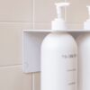 Close up of the White DESIGNSTUFF Shelf w/ Dual Soap Dispenser Holder 40cm in a bathroom with white tiles