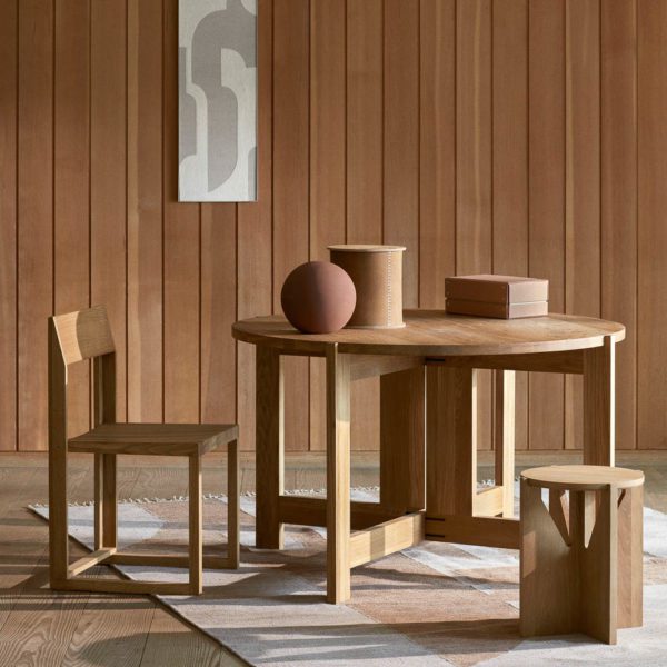 Collector dining table and a stiched leather box by Kristina Dam Studio with sculptures on the dining table. A framed print is hung on the wall.