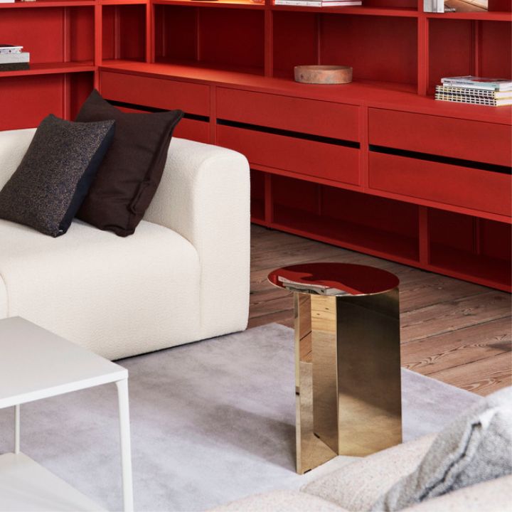 Hay's brass slit side table on a white rug in a living room