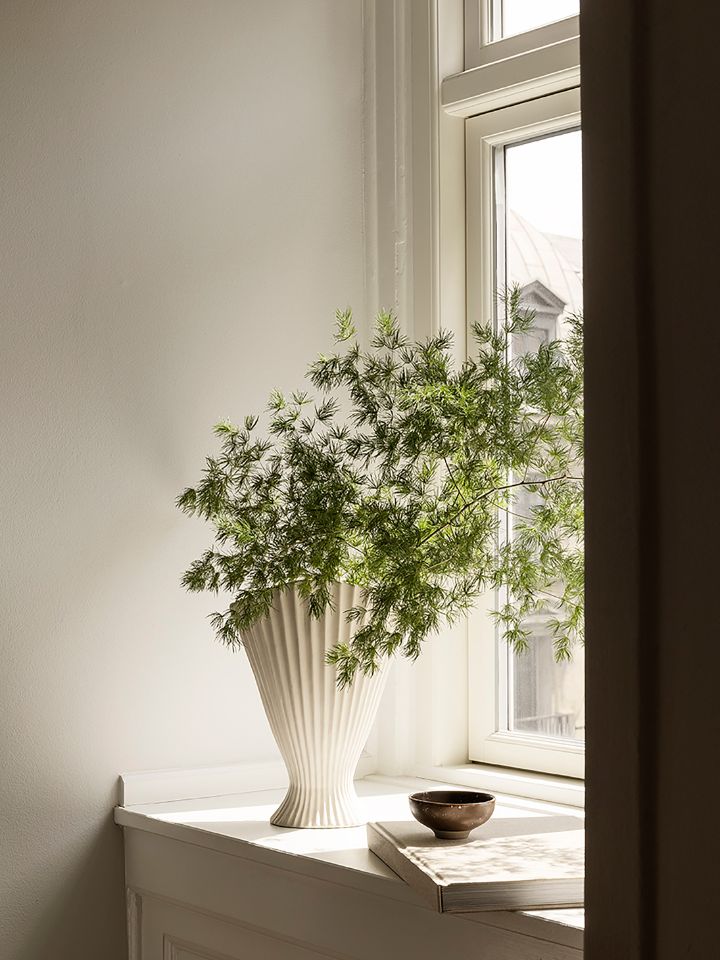 the ferm LIVING Fountain Vase styled with foliage on a windowsill
