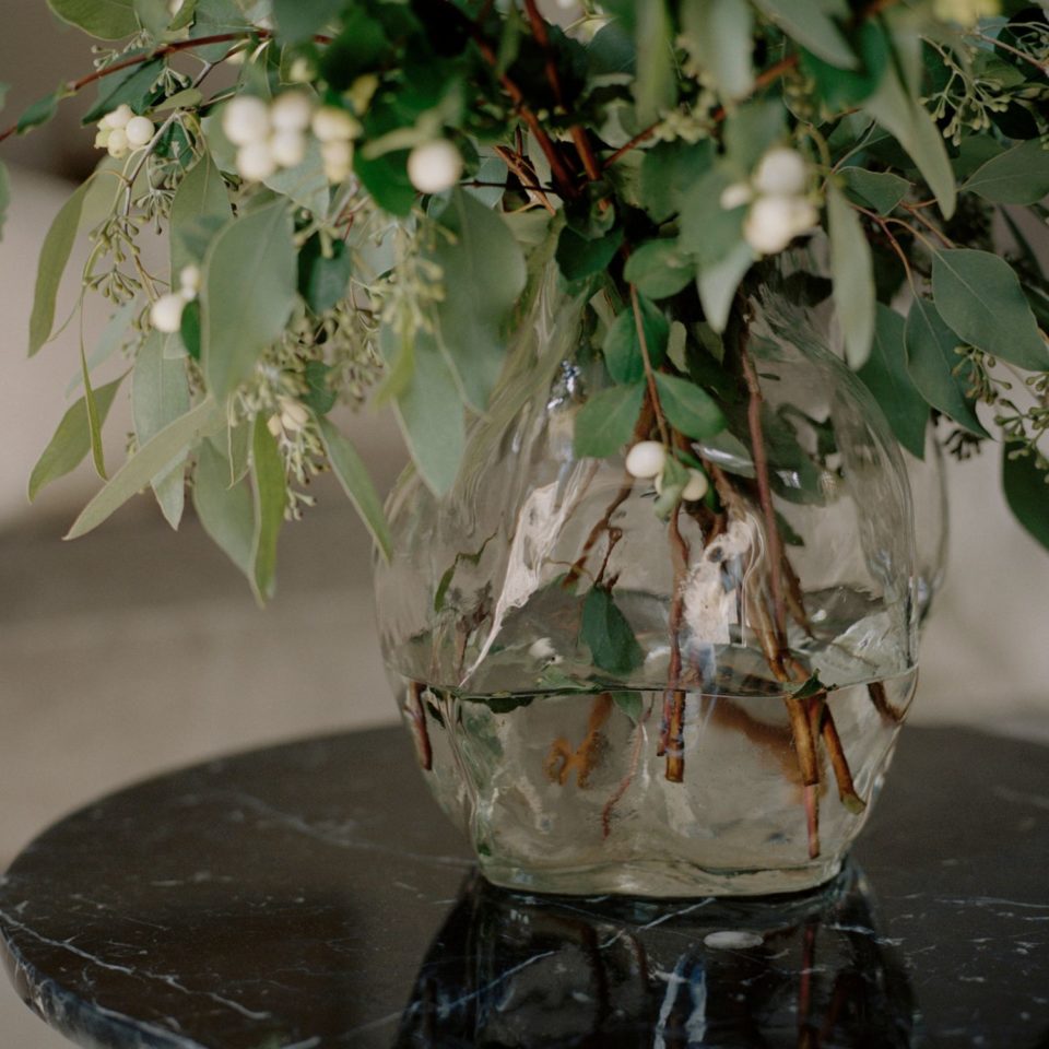 New Works Blaehr Vase in Clear, styled on a marble table with foliage