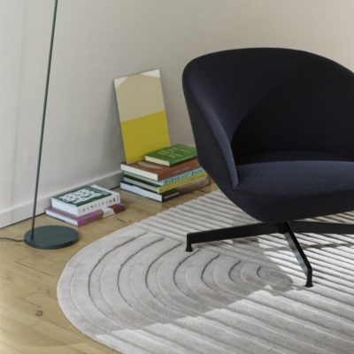 MUUTO Relevo Rug, Off White with a Black Chair on Top of It