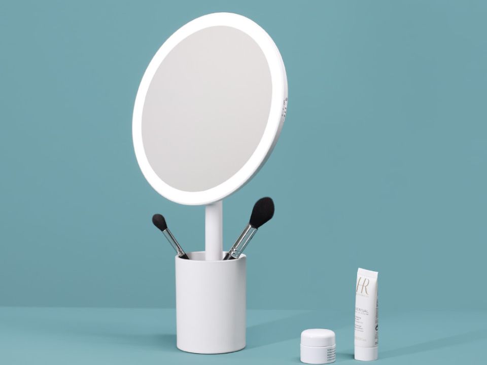 OSC's illuminated make up mirror and brush storage unit styled against a teal-blue background