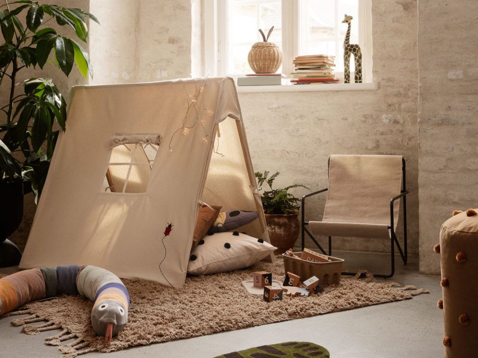 ferm LIVING's Embroidered Lady Bug tent surrounded by toys and cushions