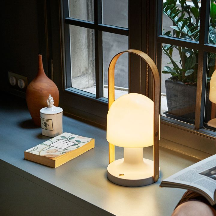 The Marset Follow Me Lamp sitting on a bench