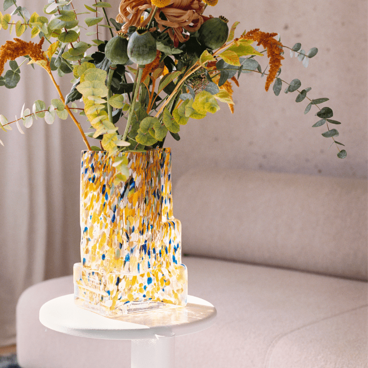This photo illustrates the 2023 design trend of Maximalism, and features a yellow, white, and blue speckled Brute vase by HEM.