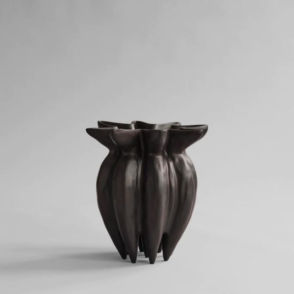 Studio photograph of a dark brown, upside down lotus shaped vase