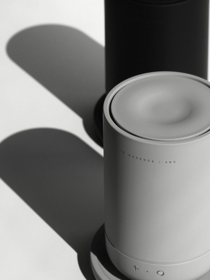 A photo of the 360 Diffuser, designed by PerCapita for In Essence. The shot is crisp, and shows the unit in grey clearly - it's a long tubular design with a plus and circle button on the front.