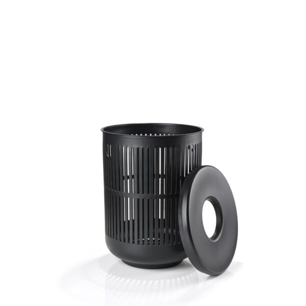 White background, studio image of a black, cylindrical laundry basket with its cover leaning beside it.