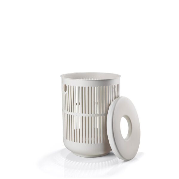 White background, perspective view, studio image of a grey, cylindrical laundry basket with its cover leaning beside it.