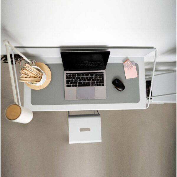 Top view of a wall-mounted desk adorned with pencils, a laptop, and an accompanying stool.