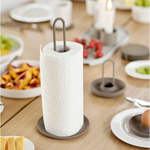 Kitchen table scene with food and with with a light brown paper towel holder in the center.