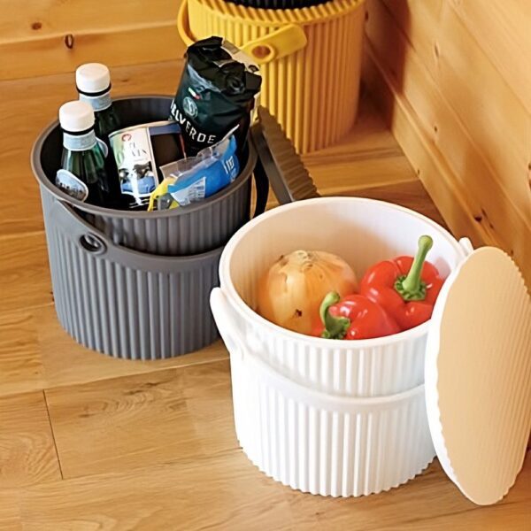 Natural light, perspective view of 3 different coloured storage bins filled with fresh vegetables and recycled bottles.