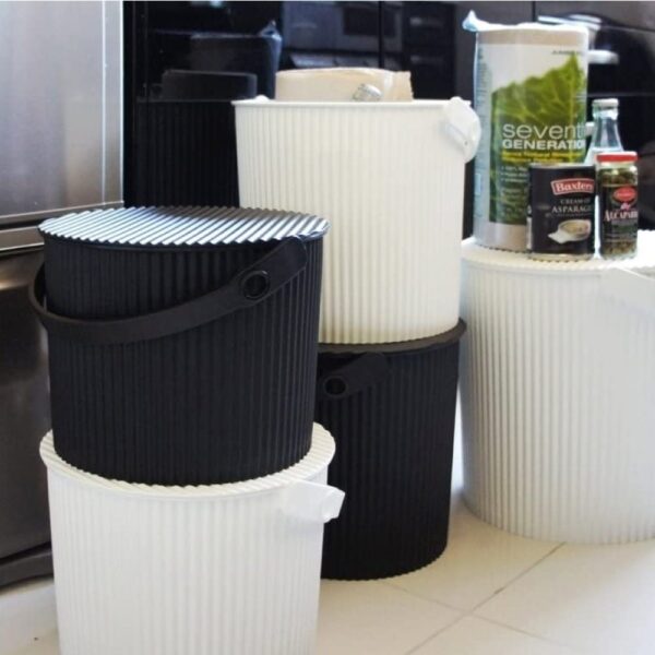 Perspective view, close up shot of black and white storage bins stacked on top of each other.