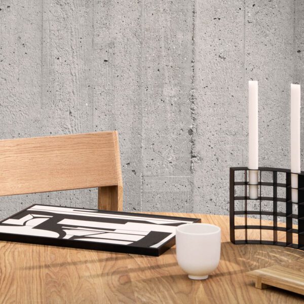 Mesh candle holder with two white candles on an oak table.