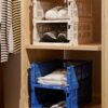A stack of colour crate clothes and shoe storage box on a shelf