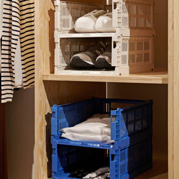 A stack of colour crate clothes and shoe storage box on a shelf