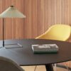 Matin table lamp with polished brass finish and white shade on dark oak table