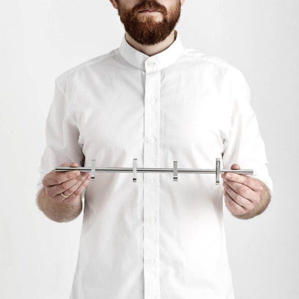 A man with beard wearing a white shirt is holding Moebe coat rack 4 pegs in chrome.