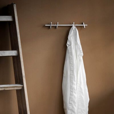 A white shirt is hung on the Moebe coat rack with 4 pegs and a ladder as bedroom decoration.