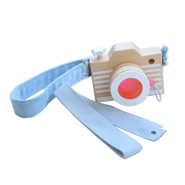 Wooden toy camera with denim straps and a removable lens.