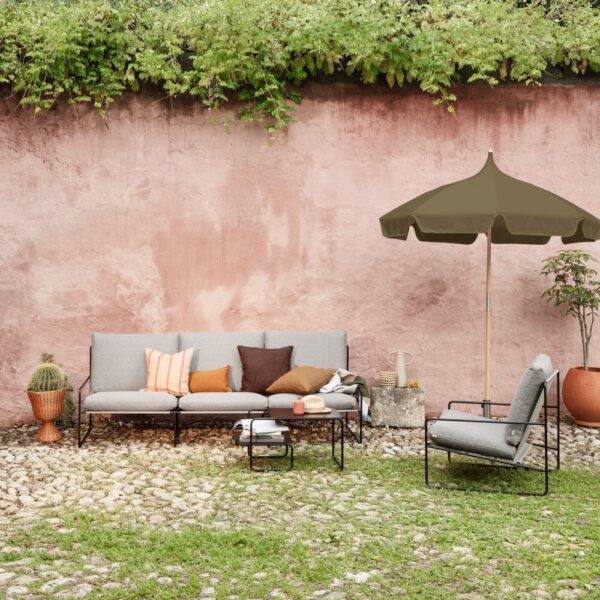 ferm LIVING Lull Umbrella in Military Green contrasting pink garden wall