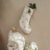 Embroided Christmas stocking made from cotton organic on the wall.