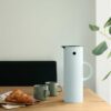Classic vacuum jug from Stelton is made of ABS plastic with a glass insert on a dining table.