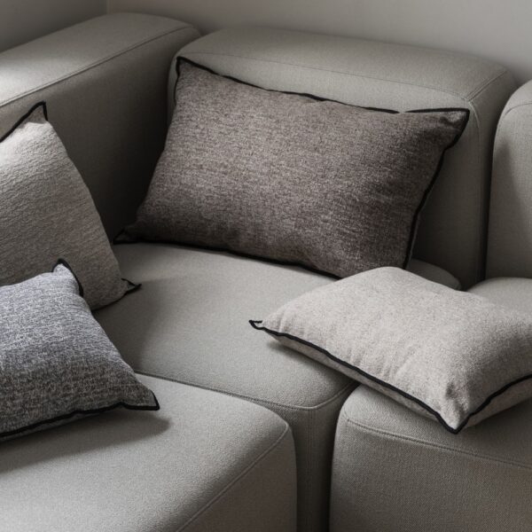 A sofa stacked with square- and rectangular shaped velvet cushions.