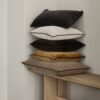 A stack of velvet cushions placed on a bench.
