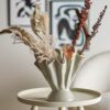 A beautiful sculptural shape and wavy look of Plier stoneware vase by Bloomingville with an art print in the background.