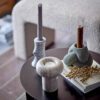 Tangle votive and candlestick with two decoratives on a wooden table. It is made from 100% stoneware in green.