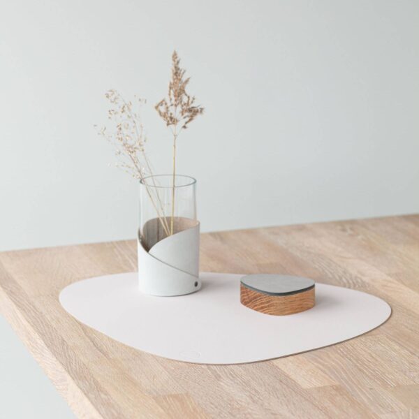 Nupo curve table mat on a dining table, made from reused leather and natural rubber.