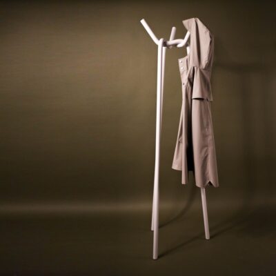 A steel coat rack in a knitted pattern with a coat hung on one of its tips.