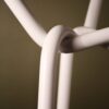 Close up of a steel coat rack in a twisted and knitted pattern