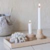 Candle holders and a shell on a marble deco tray in sand