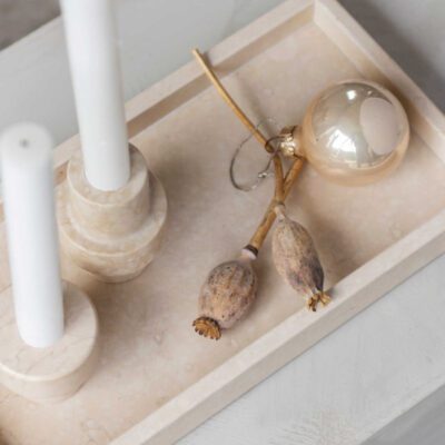 Candle holders and a jewellery on a marble deco tray in sand