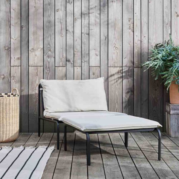 A lifestyle image of Furi outdoor chair and ottoman made from steel.
