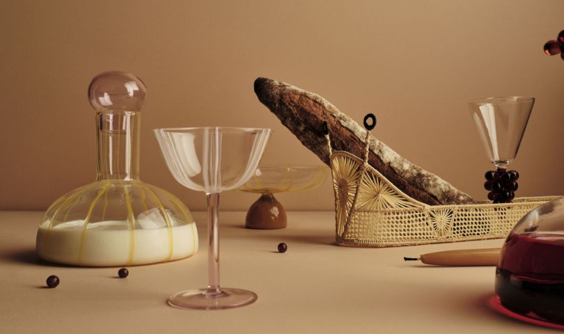 A photo of Maison Balzac's la danse collection of glassware and servingware. Styled as a still life on a brown background.