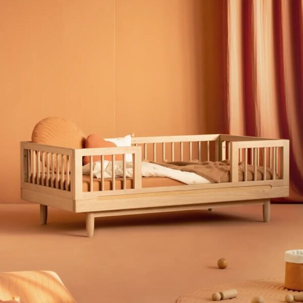 Studio lighting, perspective view of a bedroom with a kids' wooden bed frame with a security bumper installed.