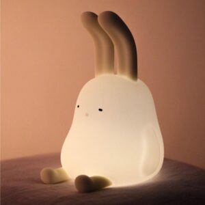 Natural lighting, perspective view of a lit kids' lamp in the shape of a rabbit.