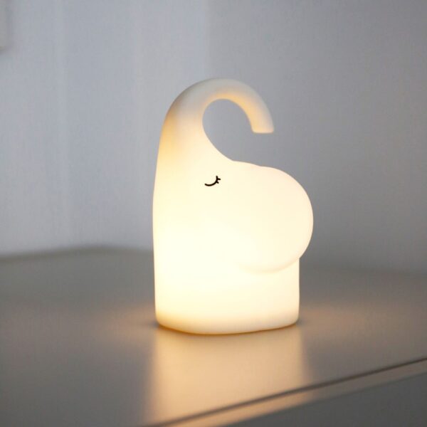 Natural light, perspective view of a lit animal-shaped lamp on a table.