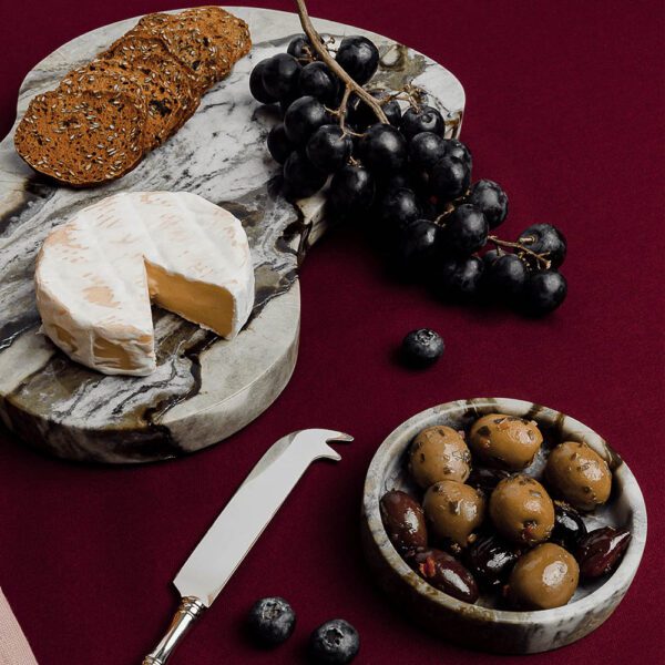Cheese and olives on a grazing serving tray made from natural jade marble.
